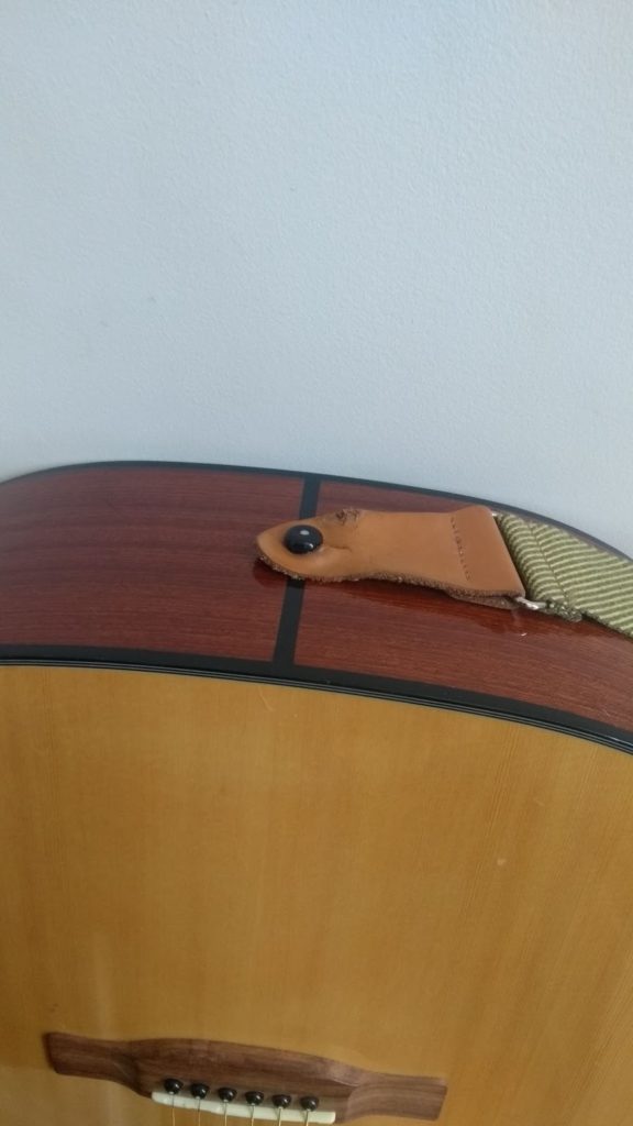 connecting to strap pin at the base of the acoustic guitar